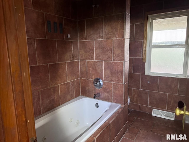 bathroom featuring tiled shower / bath combo and tile patterned flooring