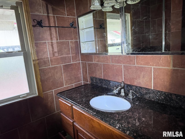 bathroom featuring a healthy amount of sunlight, tile walls, and vanity