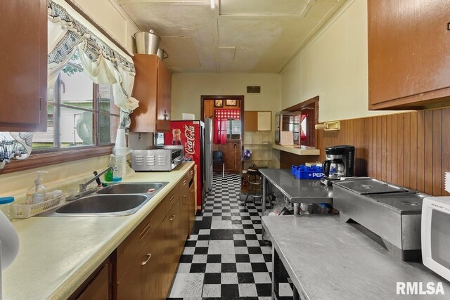 kitchen with light countertops, a sink, visible vents, white microwave, and dark floors