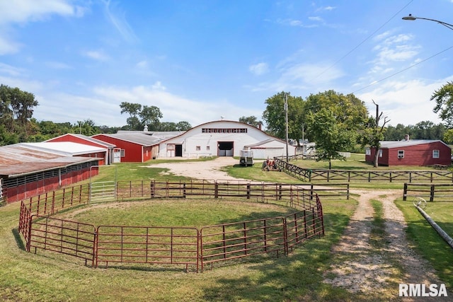 view of yard with driveway, an outbuilding, a rural view, and an exterior structure
