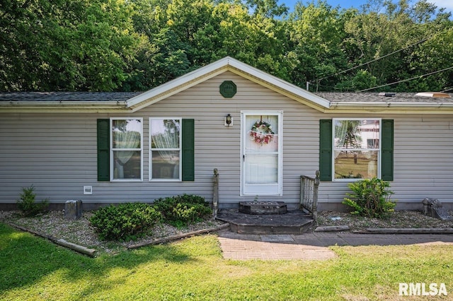single story home with a front lawn and roof with shingles