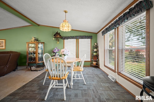 dining room featuring a textured ceiling, lofted ceiling, and dark colored carpet