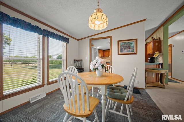 dining space featuring crown molding, vaulted ceiling, a textured ceiling, dark carpet, and visible vents
