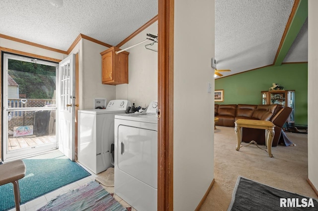 laundry area with crown molding, washing machine and clothes dryer, cabinet space, and a textured ceiling
