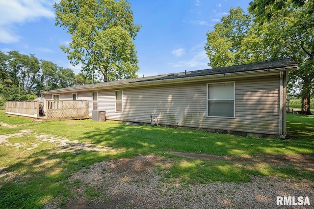 back of property with a wooden deck and a lawn