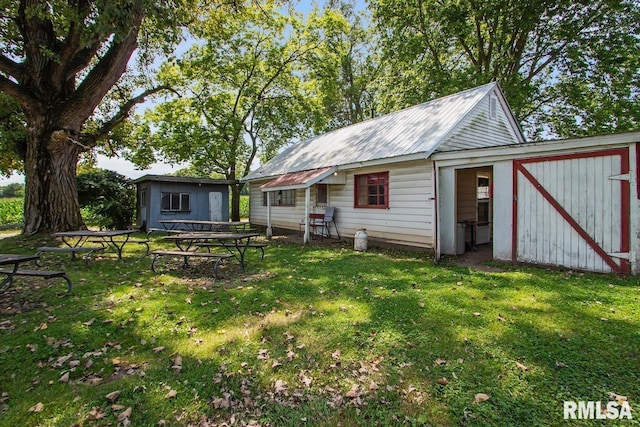 back of property featuring a yard and a shed