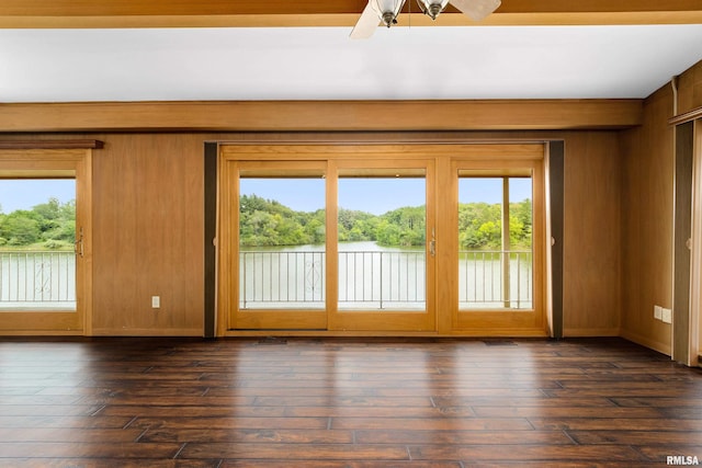 interior space featuring dark hardwood / wood-style floors, ceiling fan, and wood walls