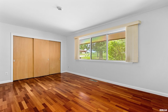 unfurnished bedroom with wood-type flooring and a closet