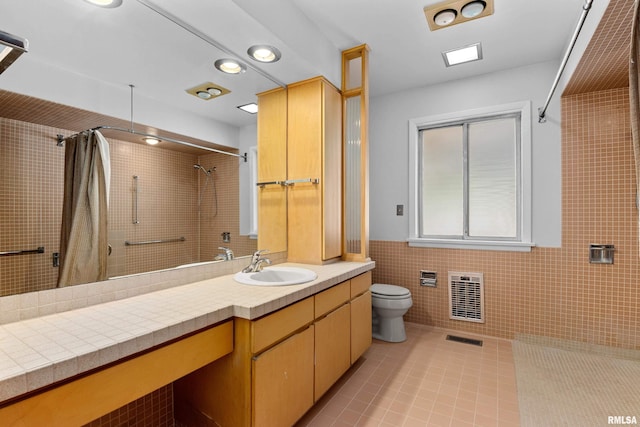 bathroom featuring tile walls, vanity, toilet, tile patterned floors, and a shower with shower curtain