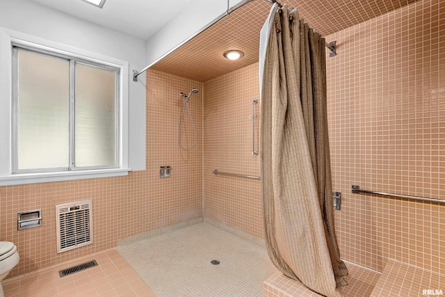 bathroom with tile walls, toilet, and a shower with shower curtain