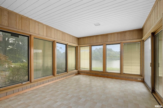 unfurnished sunroom with a water view