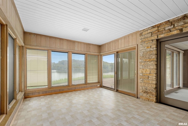 unfurnished sunroom with a water view