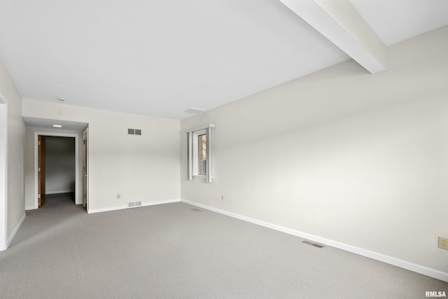 carpeted empty room with beamed ceiling