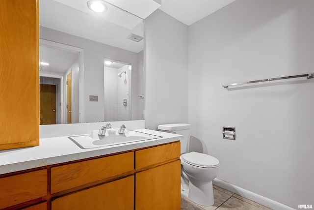 bathroom featuring walk in shower, vanity, toilet, and tile patterned flooring