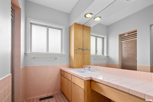 bathroom with vanity and tile walls