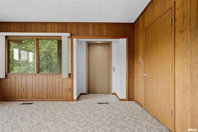 interior space with elevator and wood walls