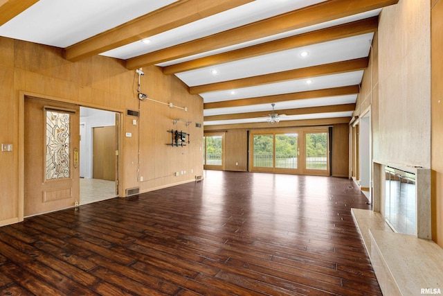 unfurnished living room with an inviting chandelier, hardwood / wood-style floors, a fireplace, and beamed ceiling