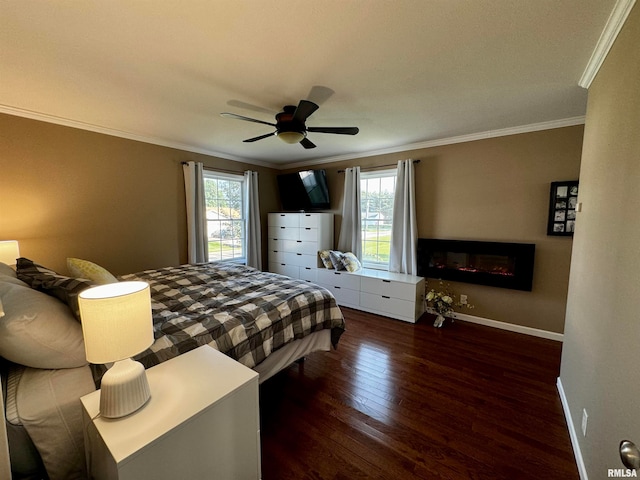 bedroom featuring ceiling fan, ornamental molding, dark hardwood / wood-style flooring, and a fireplace