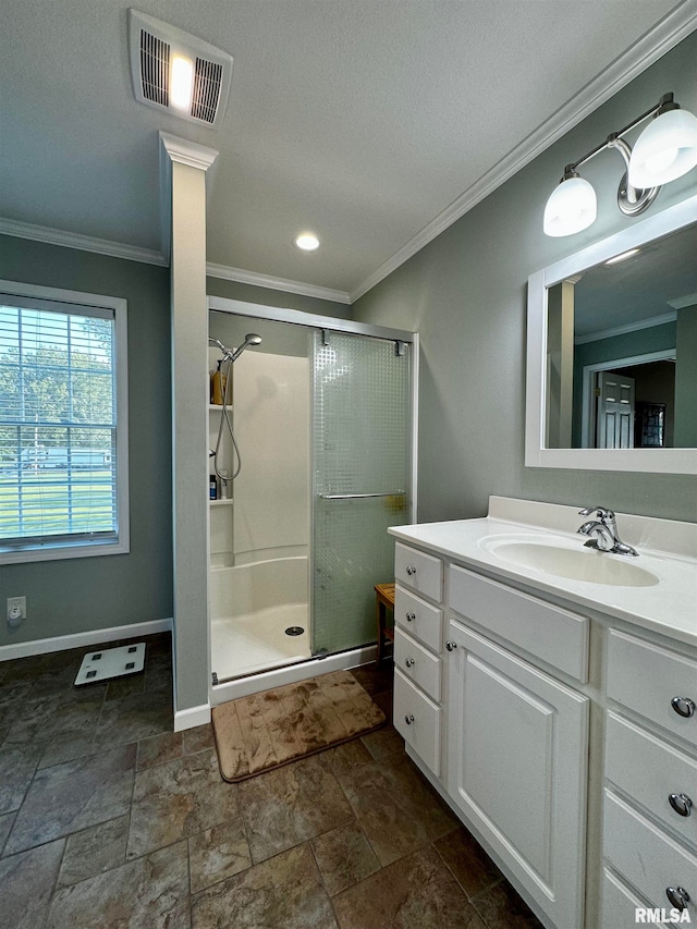 bathroom with vanity, crown molding, a textured ceiling, and a shower with door