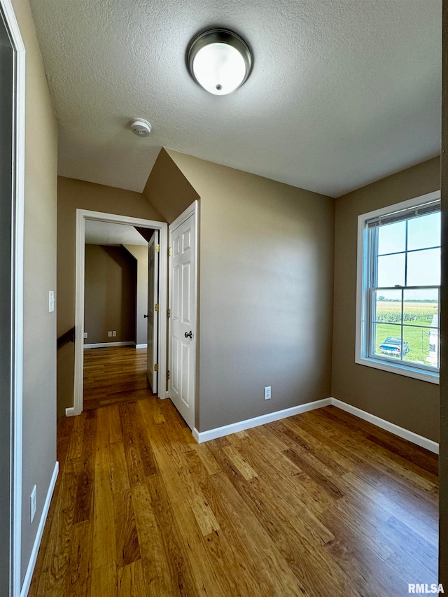 hallway with wood-type flooring and a textured ceiling