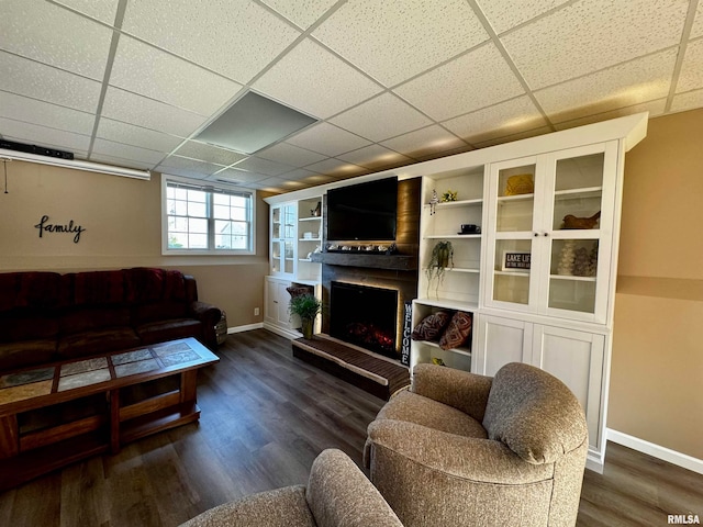 living room with dark wood-type flooring and a paneled ceiling