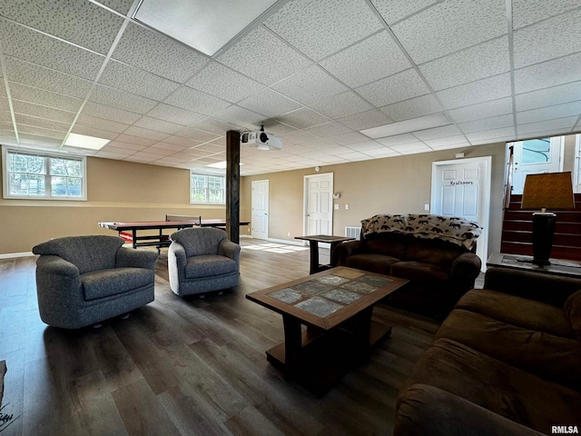 living room featuring dark hardwood / wood-style floors and a drop ceiling