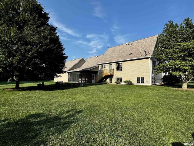 back of house with a lawn and a sunroom