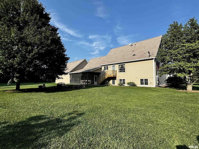 rear view of property with a yard and a sunroom