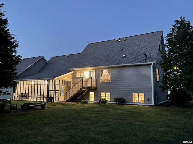 back house at dusk featuring a yard