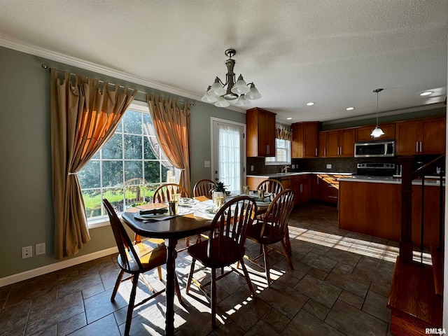 dining area with an inviting chandelier, a healthy amount of sunlight, and crown molding