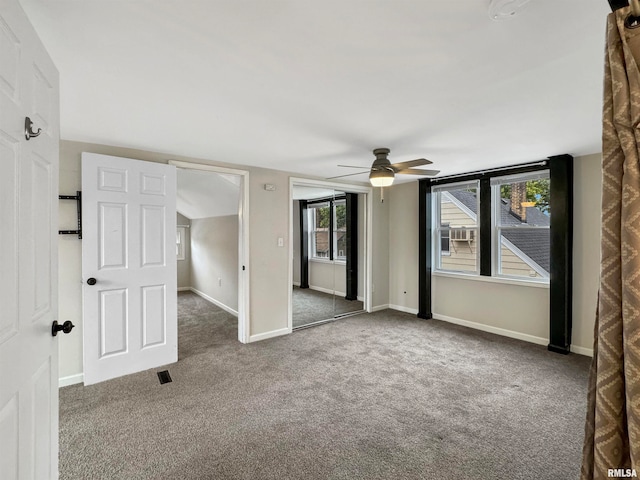 unfurnished bedroom featuring dark colored carpet and ceiling fan