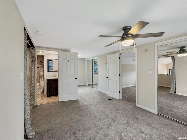 unfurnished bedroom with ceiling fan, a closet, ensuite bath, and carpet flooring