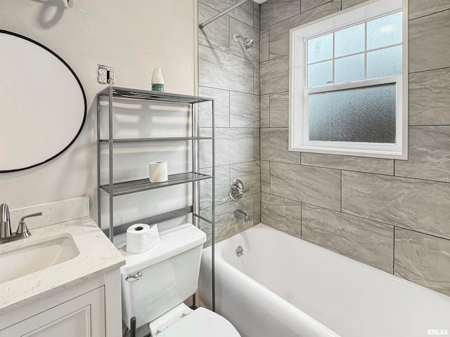 full bathroom with tiled shower / bath, vanity, and toilet