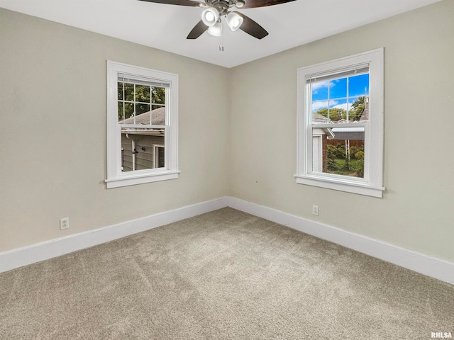 carpeted empty room featuring ceiling fan and plenty of natural light