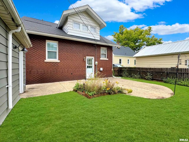 back of house with a patio and a lawn