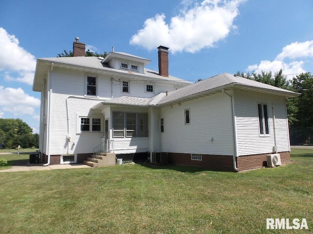 rear view of property with a yard and central AC