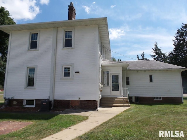 rear view of house with a yard and central air condition unit