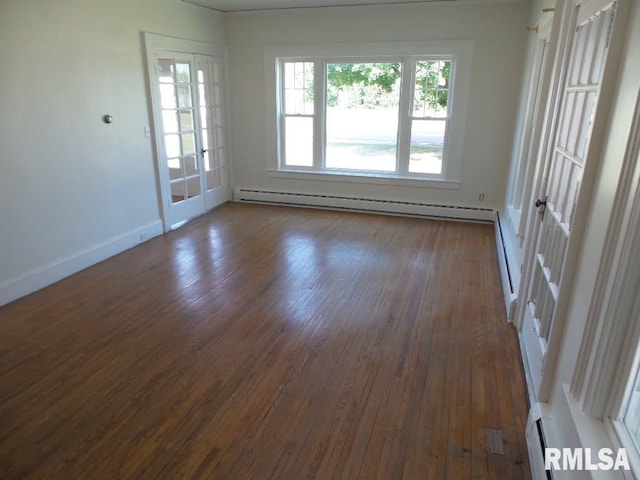 empty room featuring dark hardwood / wood-style floors and a baseboard heating unit