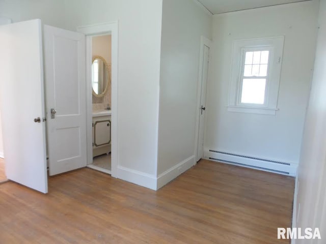 interior space with light wood-type flooring and a baseboard radiator