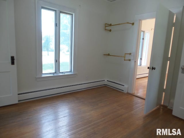 empty room featuring dark hardwood / wood-style flooring and baseboard heating