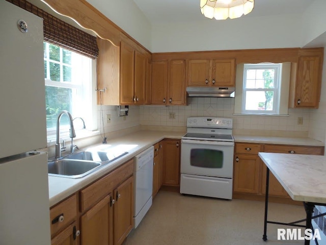 kitchen featuring white appliances, tasteful backsplash, a healthy amount of sunlight, and sink