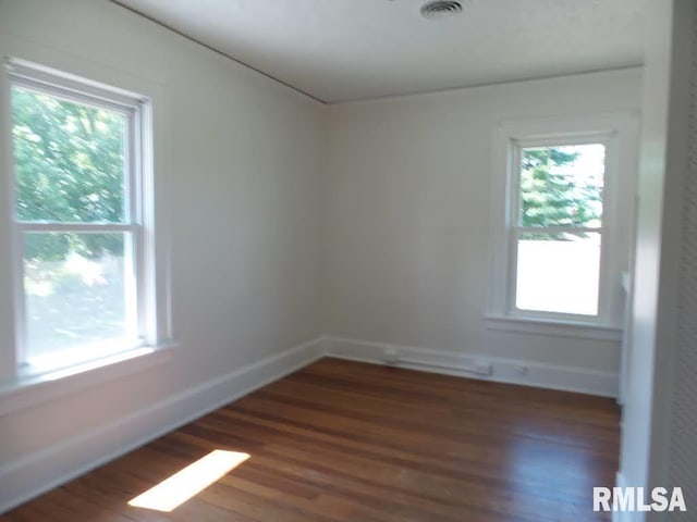 empty room featuring dark hardwood / wood-style floors and a healthy amount of sunlight