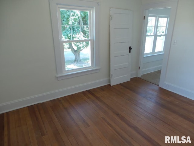 unfurnished room with dark hardwood / wood-style flooring and a healthy amount of sunlight