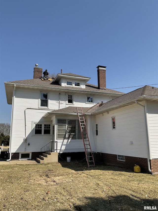 back of property featuring entry steps and a chimney