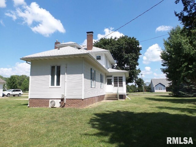 back of house featuring a yard and ac unit