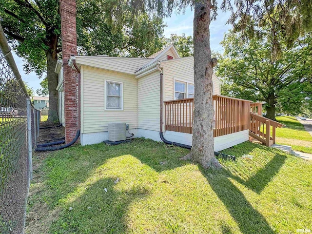 rear view of house with a wooden deck, cooling unit, and a yard