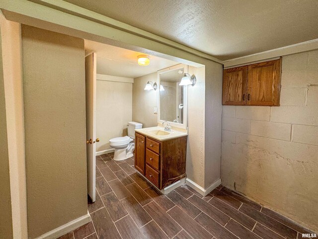 bathroom featuring a textured ceiling, vanity, and toilet