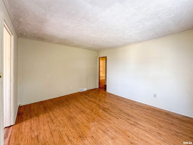 interior space with a textured ceiling and light hardwood / wood-style floors