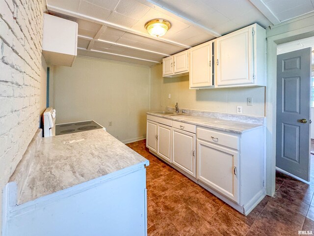 kitchen featuring sink, white cabinetry, stove, and tile patterned floors