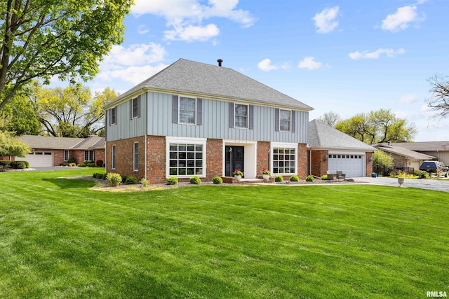 colonial-style house featuring a front yard and a garage